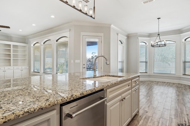 kitchen with sink, light stone counters, stainless steel dishwasher, ornamental molding, and white cabinets