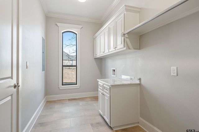 laundry room featuring washer hookup, ornamental molding, and cabinets