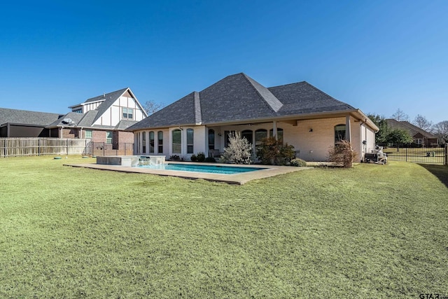 rear view of property featuring a fenced in pool and a lawn