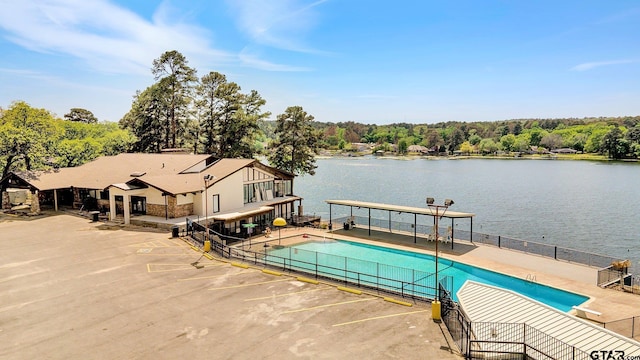 view of swimming pool with a water view and a patio