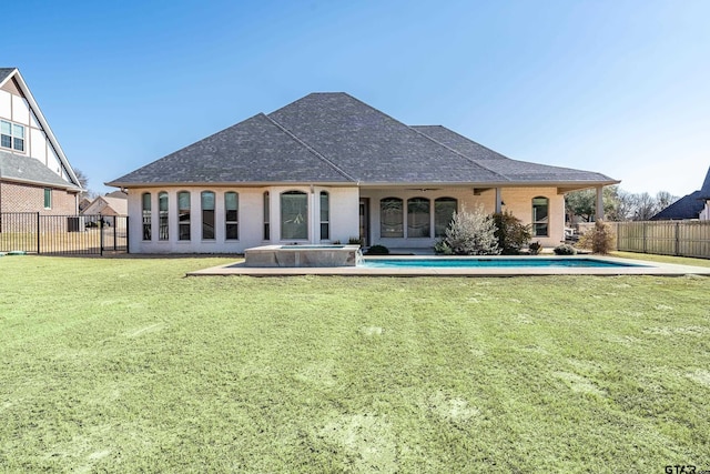 rear view of house with a yard, a pool with hot tub, and a patio