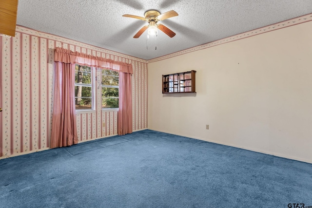 carpeted spare room featuring a textured ceiling and ceiling fan