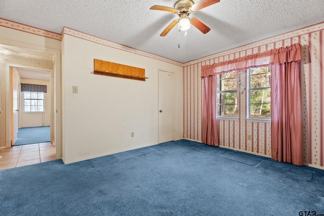 spare room with carpet flooring, a textured ceiling, and ceiling fan