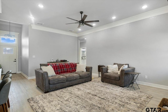 living room featuring crown molding, ceiling fan, and light wood-type flooring