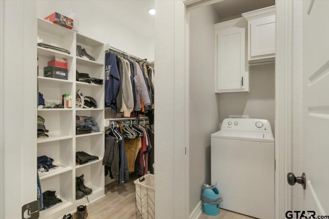 clothes washing area with washer / clothes dryer, cabinets, and light hardwood / wood-style floors