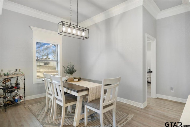 dining room with light hardwood / wood-style flooring and ornamental molding