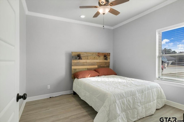 bedroom with crown molding, ceiling fan, and light hardwood / wood-style flooring