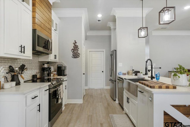 kitchen with white cabinetry, appliances with stainless steel finishes, and hanging light fixtures