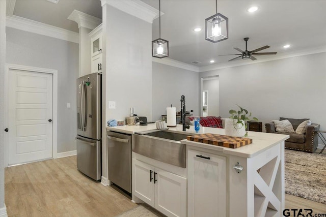 kitchen featuring white cabinetry, decorative light fixtures, light hardwood / wood-style flooring, and appliances with stainless steel finishes