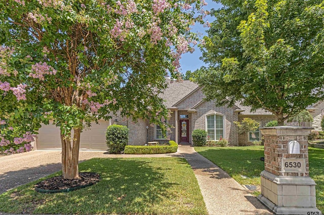 6530 Ashmore Ln, Tyler, TX 75703 - view of front facade featuring brick siding, a front yard, driveway, and a shingled roof