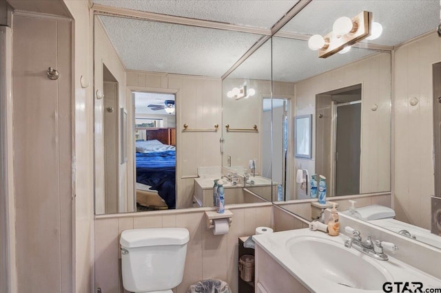 bathroom with vanity, a shower with shower door, a textured ceiling, and toilet