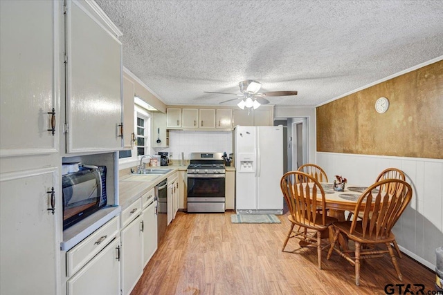 kitchen featuring white cabinets, appliances with stainless steel finishes, crown molding, and light hardwood / wood-style flooring