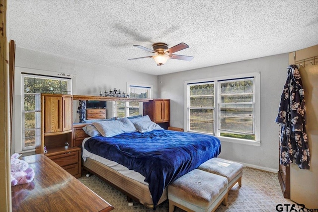 carpeted bedroom featuring a textured ceiling and ceiling fan