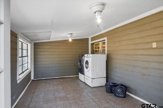 laundry area featuring wooden walls and washer and clothes dryer