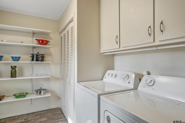 laundry room with dark hardwood / wood-style flooring, cabinets, washing machine and dryer, and crown molding