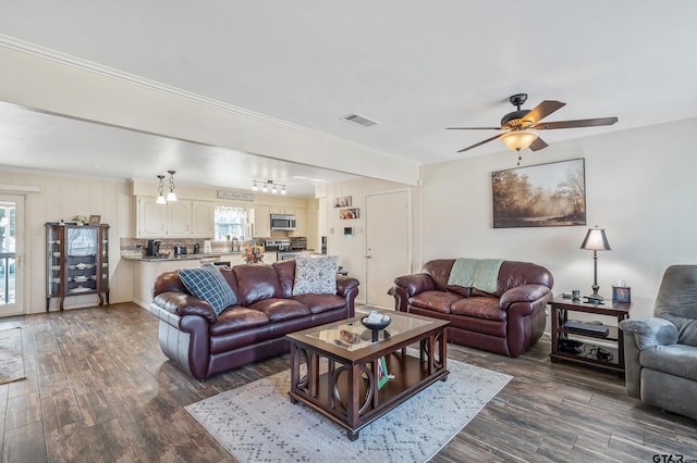 living room with dark hardwood / wood-style flooring and crown molding