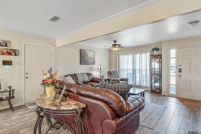 living room featuring ceiling fan and crown molding