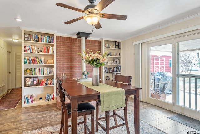 dining room with hardwood / wood-style floors, ornamental molding, ceiling fan, and a wood stove