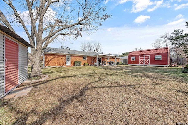 rear view of house with a yard and an outbuilding