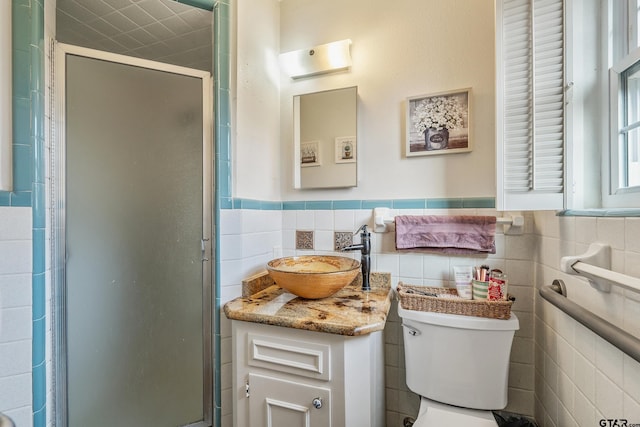 bathroom featuring toilet, vanity, tile walls, and walk in shower