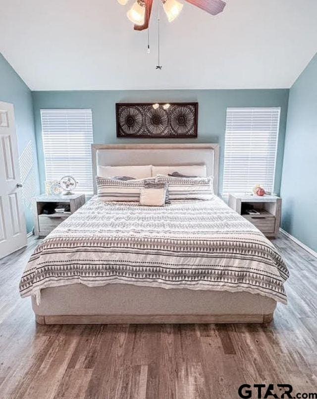 bedroom featuring ceiling fan, vaulted ceiling, and hardwood / wood-style flooring