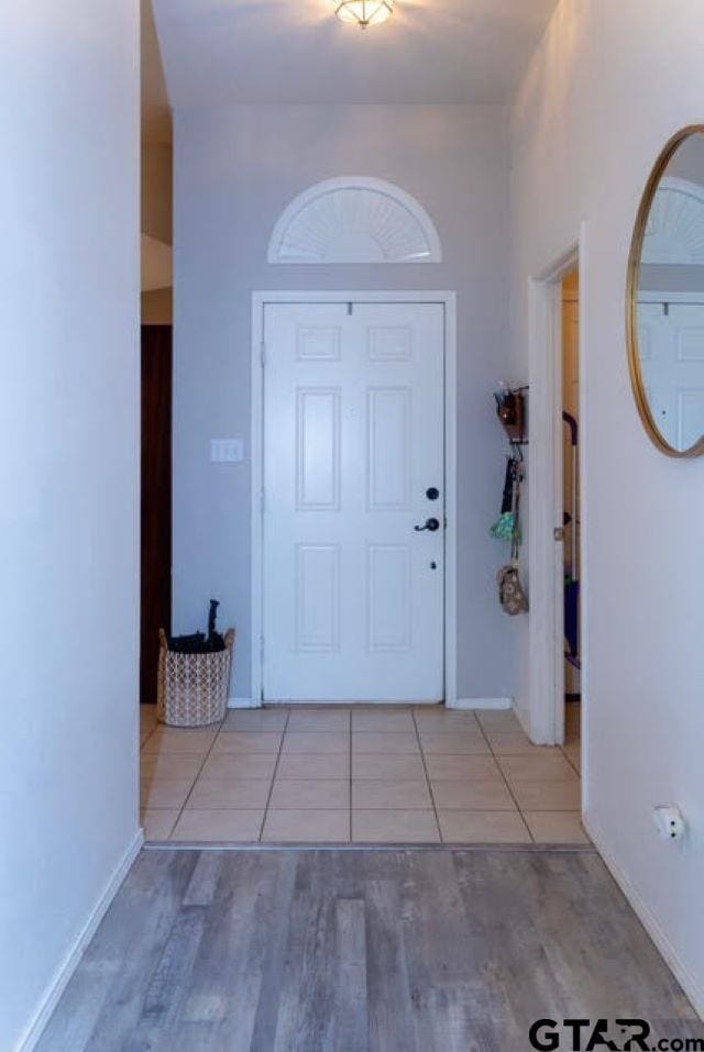 foyer entrance featuring baseboards and wood finished floors