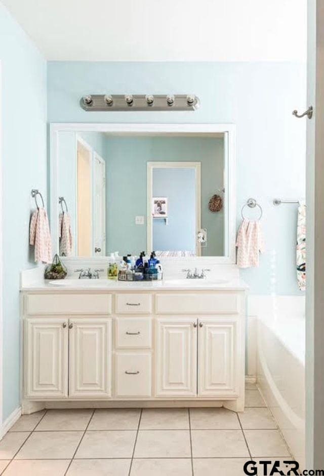 bathroom with tile patterned floors, vanity, and a tub to relax in