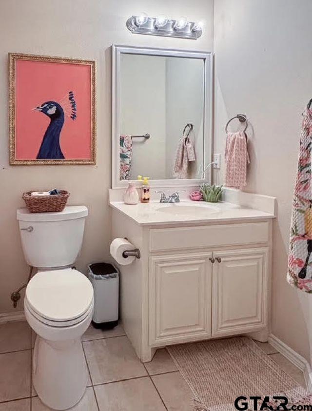 bathroom featuring tile patterned flooring, vanity, and toilet