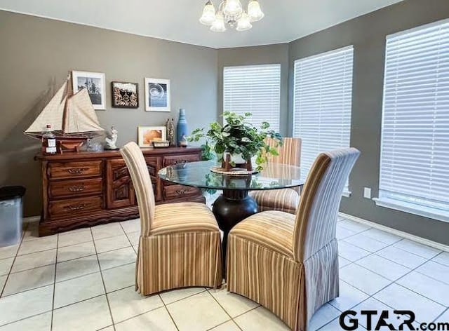 dining space featuring a notable chandelier, baseboards, and light tile patterned floors