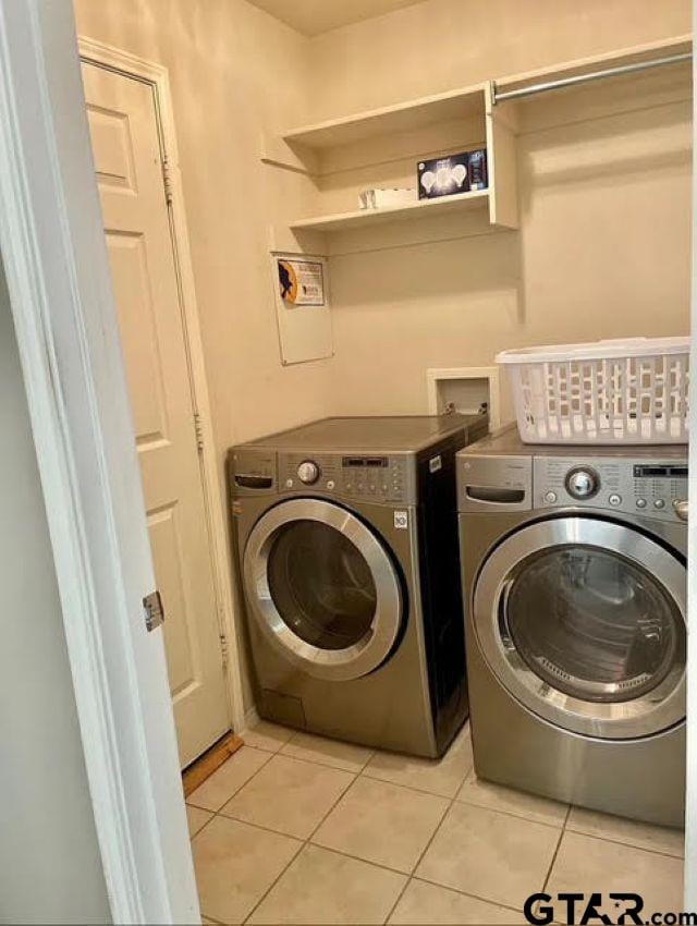 laundry area featuring light tile patterned flooring and washing machine and dryer