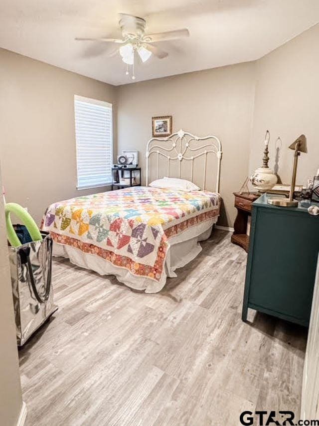 bedroom with ceiling fan, baseboards, and light wood-style flooring