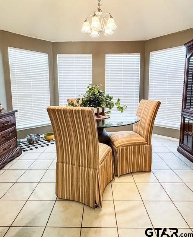 dining room featuring light tile patterned flooring and a notable chandelier