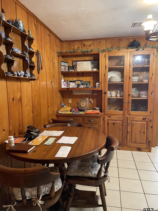 105 Walker Dr, Naples, TX 75568 - dining space featuring a textured ceiling, light tile patterned floors, and wooden walls