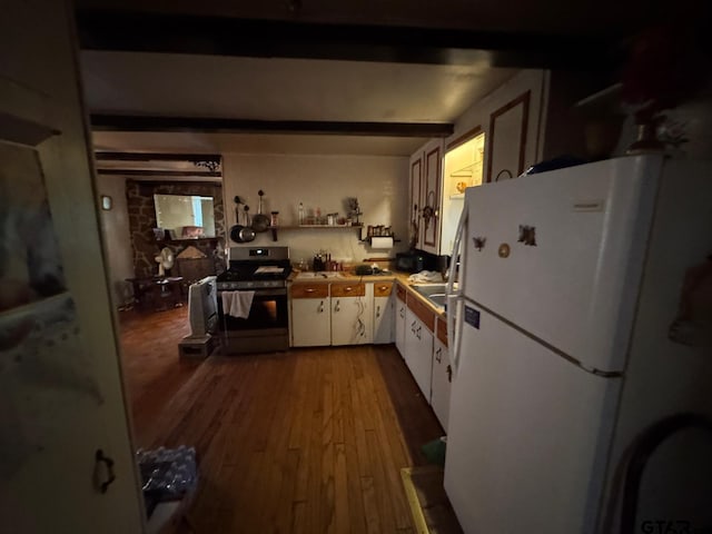 kitchen featuring white cabinets, gas range, hardwood / wood-style flooring, beam ceiling, and white fridge