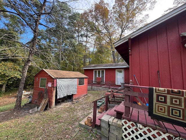 view of yard featuring a deck and a storage unit