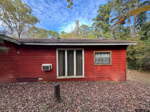 view of side of property with an AC wall unit