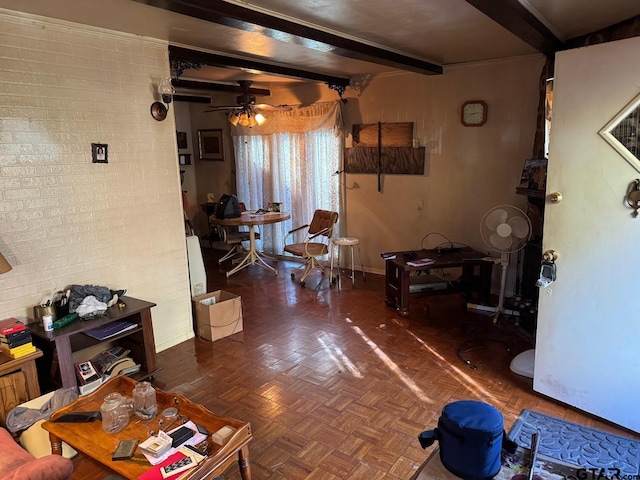 living room featuring beam ceiling, dark parquet flooring, ceiling fan, and brick wall