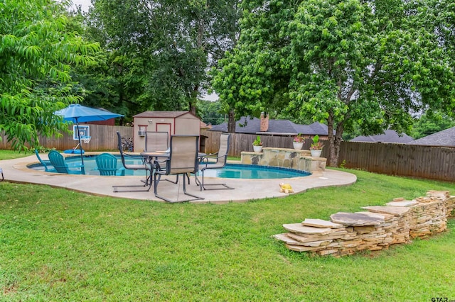 view of pool featuring a yard, a patio, and a shed