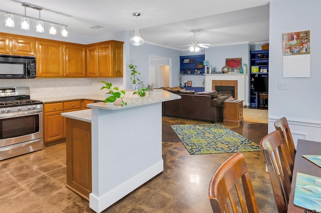 kitchen with pendant lighting, a tile fireplace, gas range, ceiling fan, and light stone countertops