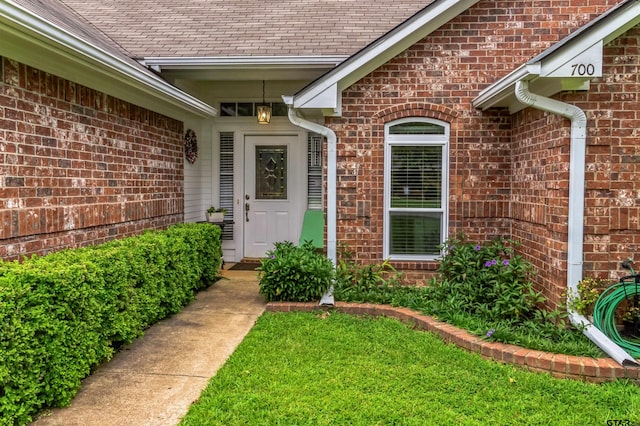 doorway to property featuring a lawn