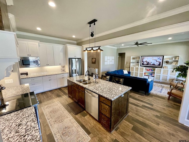 909 Charlie, Whitehouse, TX 75791 - kitchen with stainless steel appliances, a sink, dark wood finished floors, white cabinets, and ornamental molding