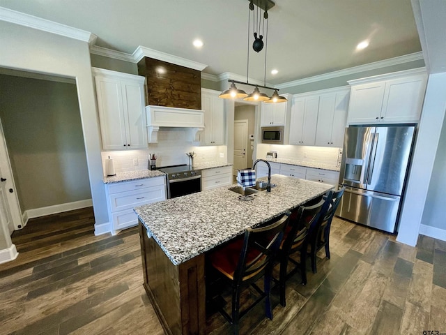 909 Charlie, Whitehouse, TX 75791 - kitchen featuring stainless steel appliances, a sink, ornamental molding, baseboards, and a center island with sink