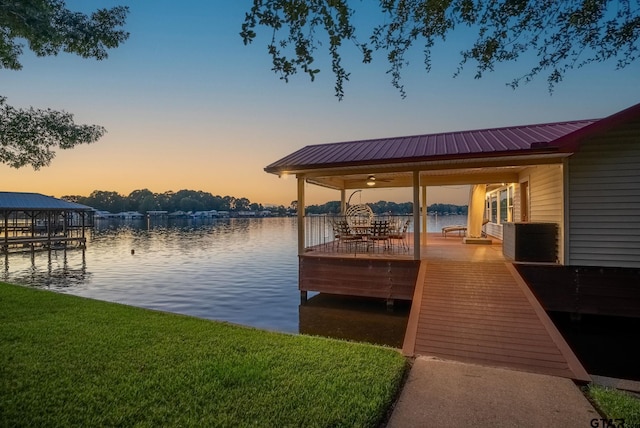 dock area featuring a water view and a lawn