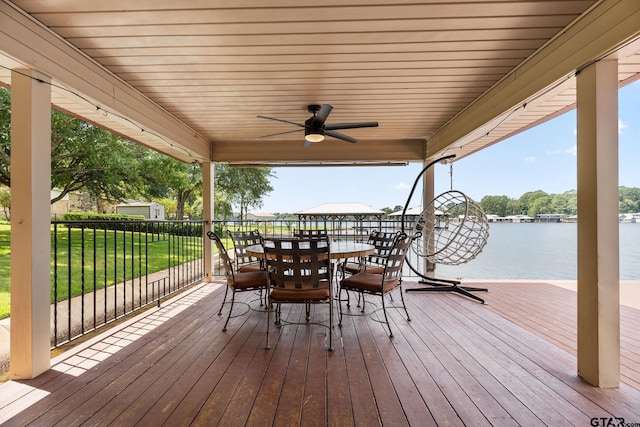 wooden deck featuring a water view, a yard, and ceiling fan