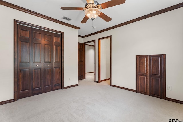 unfurnished bedroom featuring ornamental molding, light carpet, ceiling fan, and a closet