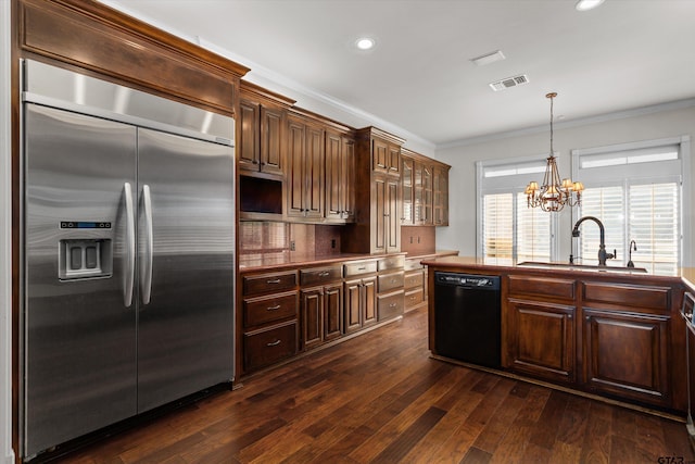 kitchen with built in fridge, sink, black dishwasher, dark brown cabinets, and a chandelier