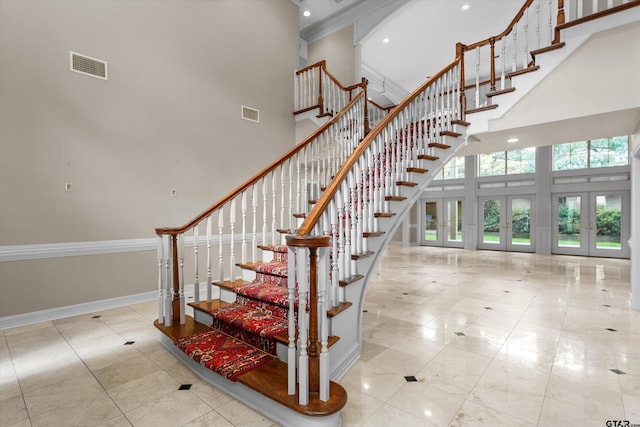 stairway featuring a high ceiling and french doors