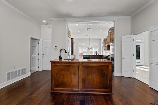 kitchen featuring kitchen peninsula, dark hardwood / wood-style flooring, a chandelier, and ornamental molding