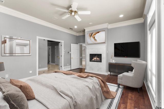 bedroom with ceiling fan, a fireplace, wood-type flooring, and ornamental molding