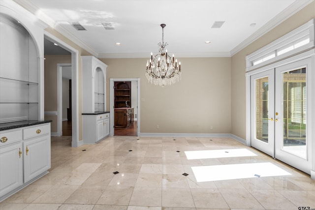 unfurnished dining area with crown molding, french doors, and an inviting chandelier